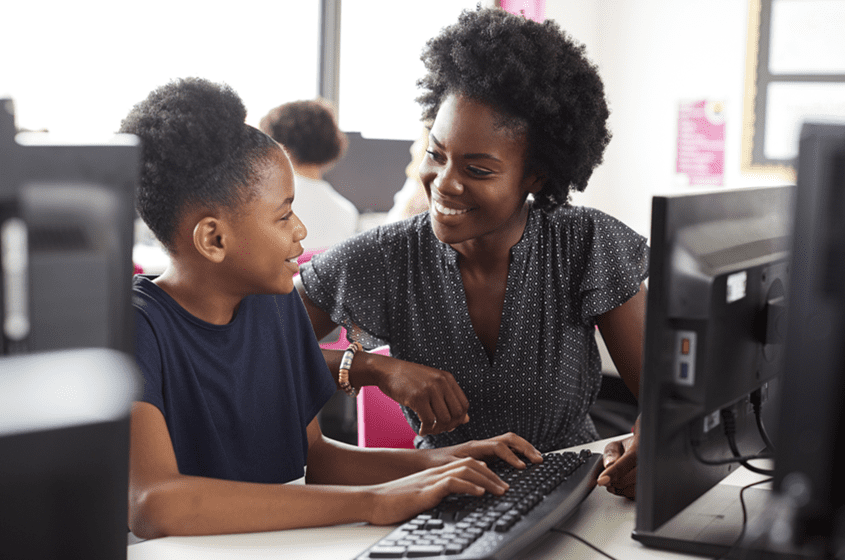 An IT Pro works with a child who is learning to Code